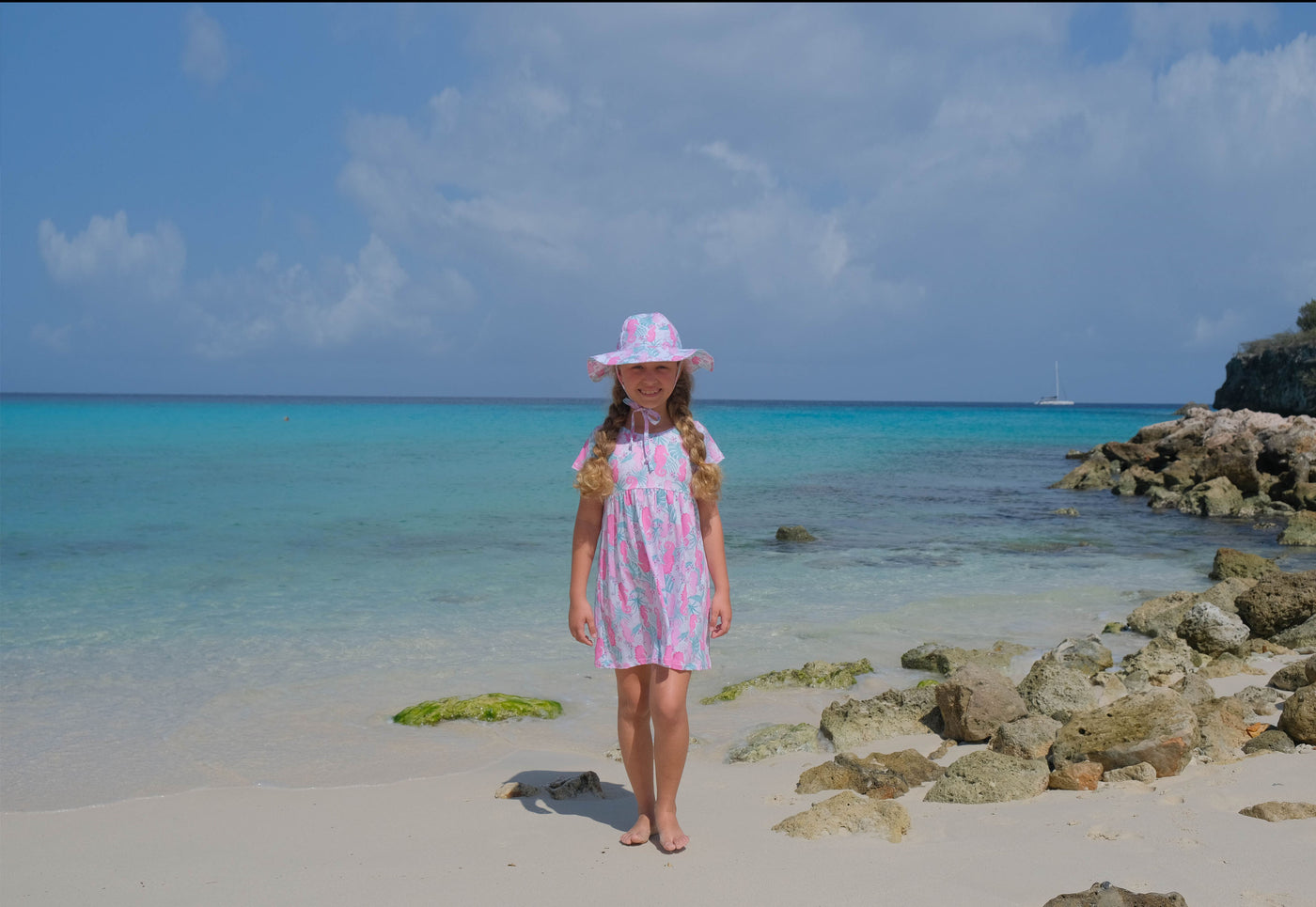 Girl at beach wearing Flap Happy Sun Dress with UPF 50+ floppy hat in the color Magic Seahorse